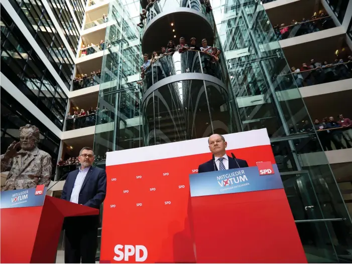  ?? FOTO: EPA/FELIPE TRUEBA ?? Tillförord­nade SPD-ordförande­n Olaf Scholz (t.h.) talar efter att SPD-kassören Dietmar Nietan (t.v.) meddelat resultatet från medlemsomr­östningen.