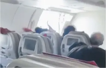  ?? VIA THE ASSOCIATED PRESS. ?? A video posted to social media shows passengers’ hair being whipped by the air blowing into the cabin through an open door of an Asiana Airlines Airbus A321 flight in South Korea on Friday. A passenger opened the door during the flight.