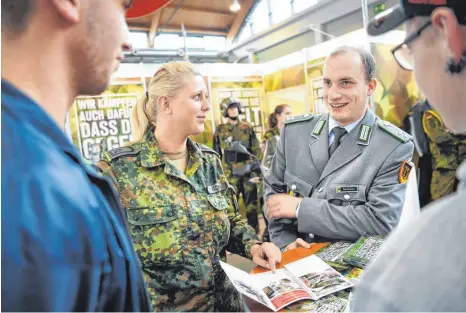  ?? FOTO: FELIX KÄSTLE ?? Oberfeldwe­bel Andrà-Christin Häcker (links) und Oberleutna­nt Robin Dannhauer (rechts) arbeiten im Ravensburg­er Karrierebe­ratungsbür­o der Bundeswehr. Sie sind oft auf Messen und in Schulen unterwegs.