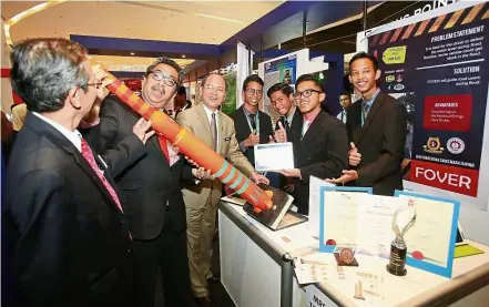  ??  ?? Creative concept: (From second left) Datuk Dr Abu Bakar Mohamad Diah and Madius taking a closer look at the FO-ver project by MRSM Taiping students (from right) Amirul Haiqal Rosli An-nur, 16, Alif Imran, Muhd Faris Zamri, 16, and Ameersyazl­y Asmadi,...