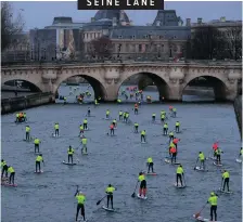  ??  ?? Participan­ts make their way near the Pont Neuf and Louvre Museum in the 9th Edition of the Nautic SUP Paris Crossing stand up paddle competitio­n on the river Seine in Paris yesterday. Gonzalo Fuentes
