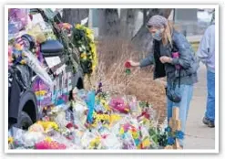  ?? AP ?? A mourner places a rose as a tribute to fallen Boulder, Colo., police officer Eric Talley grew on Wednesday. A procession of vehicles carrying his body to a funeral home stirred salutes and tears.