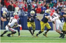  ?? ASSOCIATED PRESS FILE PHOTO ?? Notre Dame running back Josh Adams, center, cuts in front of Georgia linebacker Roquan Smith (3) during the first half of Saturday night’s game in South Bend, Ind. Georgia won 20-19.