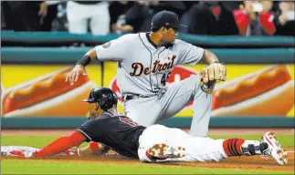  ?? Ron Schwane ?? The Associated Press Francisco Lindor slides in with a three-run triple as Tigers third baseman Jeimer Candelario awaits a throw in the second inning of the Indians’ 11-0 victory Monday at Progressiv­e Field.