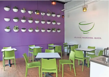  ?? PETERSON / MILWAUKEE JOURNAL SENTINEL ANGELA ?? Bowl-shaped planters hold herbs and other plants on a purple wall at Bowls, a counter-service restaurant selling healthier fare.