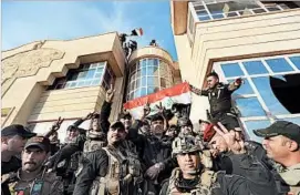  ?? KHALID MOHAMMED/AP ?? Iraqi counterter­rorism forces raise the country’s flag Friday after retaking Bartella, a historical­ly Christian town near Mosul, where Iraqi forces launched an offensive Monday.