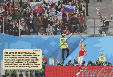  ?? AP PHOTO ?? FOR LOVE OF COUNTRY: Russia’s Denis Cheryshev celebrates in front of a frenzied crowd after scoring the team’s second goal in the 59th minute of yesterday’s 3-1 victory against Egypt in a World Cup Group A match in St. Petersburg, Russia.
