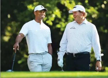  ?? CURTIS COMPTON/TRIBUNE NEWS SERVICE ?? Tiger Woods and Phil Mickelson share a laugh on the 11th tee while playing a practice round for the Masters at Augusta National Golf Club on Tuesday in Augusta, Ga.