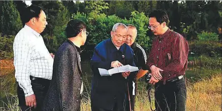  ?? PROVIDED TO CHINA DAILY ?? Zhou Yongkai (middle) talks with local officials during a field trip to the Hua’e Mountain in Sichuan province.