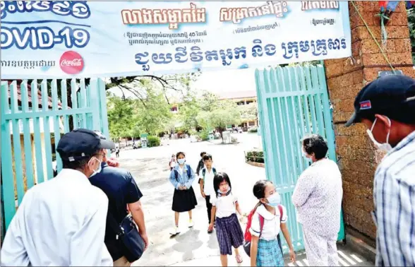  ?? HONG MENEA ?? Students wearing face masks for protection from Covid-19 walk out of a school in Phnom Penh’s Meanchey district in November last year.