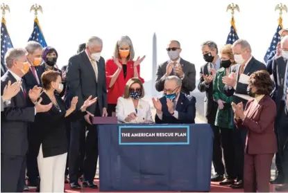  ?? ALEX BRANDON/AP ?? House Speaker Nancy Pelosi and Senate Majority Leader Chuck Schumer celebrate Wednesday after signing the $1.9 trillion COVID-19 relief bill, during a ceremony on Capitol Hill.