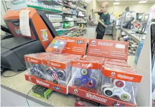  ?? AP ?? LEFT Fidget spinner toys are displayed at a 7-Eleven convenienc­e store in Warren, Michigan.