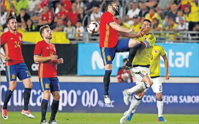  ??  ?? DISPUTADO. Nacho salta junto a James, su compañero en el Real Madrid, intentando evitar el remate del delantero colombiano.