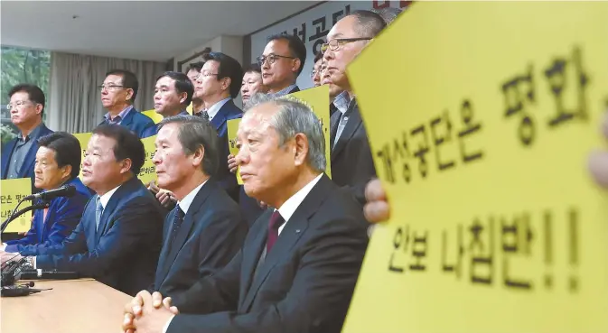  ?? Yonhap ?? Corporate Associatio­n of Gaeseong Industrial Complex President Shin Han-yong, second from left in the front row, demands that the government allow them to visit North Korea, during a press conference with other associatio­n members in Seoul, Oct. 11.