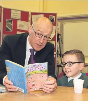  ??  ?? Mr Swinney reading with Jaiden Guthrie, 7, at St Francis Primary School.