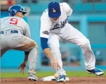  ?? Robert Gauthier Los Angeles Times ?? THE CUBS’ Javier Baez is safe at second when Dodgers infielder Chase Utley bobbles a throw from Corey Seager in second inning.