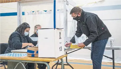  ?? LIAM RICHARDS THE CANADIAN PRESS ?? Saskatchew­an Party Leader Scott Moe completes his voter registrati­on before voting in Shellbrook, Sask., on Monday.