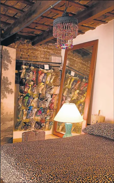  ??  ?? PERSONAL. El biombo con los zapatos a la vista, la colcha animal print y (a la izquierda) la lámpara vintage.