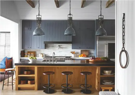  ??  ?? KITCHEN Robert and the owners wanted a ‘Hamptons slash American country farmhouse feel’.
Vintage industrial enamel shade hanging lights can be sourced via Robert Stilin on 1stdibs. Find Belgian fossil limestone worktops like these at MKW Surfaces. Nkuku’s Narwana leather round bar stools are similar