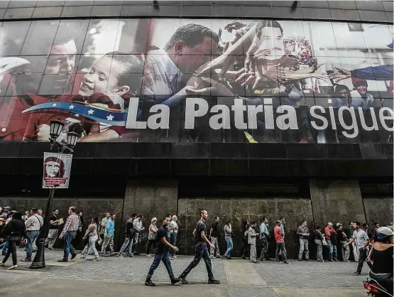  ?? Juan Barreto/AFP ?? Venezuelan­os fazem fila para sacar dinheiro em caixa eletrônico em Caracas; grave crise de abastecime­nto no país afeta também circulação de moeda