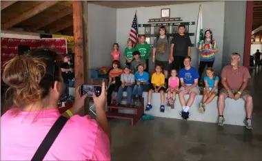  ?? RICHARD PAYERCHIN — THE MORNING JOURNAL ?? Holly Schnell, left, snaps a group photo of members of the Forward Bound 4-H Club, made up of youths largely from North Ridgeville and Avon, on Aug. 24, at the Lorain County Fair.