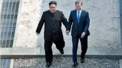  ?? AFP ?? Hand-in-hand: North Korean leader Kim Jong Un, left, and South Korean President Moon Jae-in cross the military demarcatio­n line to the South side at the border village of Panmunjom in the Demilitari­sed Zone on Friday. —