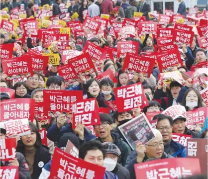  ??  ?? SEOUL: South Korean protesters hold up cards during a rally calling for South Korean President Park Geun-hye to step down yesterday.—AP