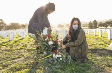  ?? Gabrielle Lurie / The Chronicle ?? Above: Twins Jasmine Igtanloc ( left) and Jenilee Silva put fresh flowers at their father’s grave in San Bruno. Below: Jesus ( left) and wife Mariquita Baluyot, shown in a family photo, were stricken with COVID19.