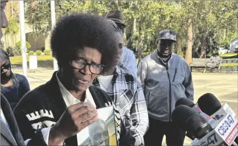  ?? AP PHOTO/RUSS BYNUM ?? Mary Cure holds a framed photo of her slain son, Leonard Cure, as she speaks to reporters on Wednesday in Woodbine, Ga.