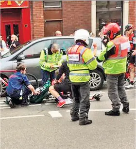  ??  ?? Down and out: Brent Bookwalter is treated after crashing into the car in Retford