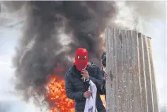  ?? REUTERS ?? A Kashmiri protester stands in front of a burning tyre during a protest near the site of a gun battle between Indian security forces and suspected militants in Srinagar.