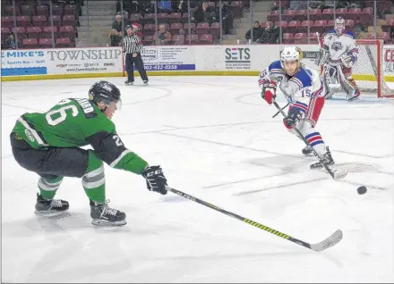  ?? JASON SIMMONDS/JOURNAL PIONEER ?? Summerside Western Capitals defenceman Michal Sivek clears the puck while being pressured by the Grand Falls Rapids’ Mark Richard during first-period action of Saturday night’s MHL (Maritime Junior Hockey League) game at Eastlink Arena. The Caps won the contest 7-1.