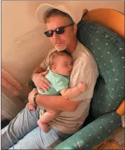  ??  ?? Budd Reigner cuddles up with his 3-month-old grandson, Nicholas Morris.