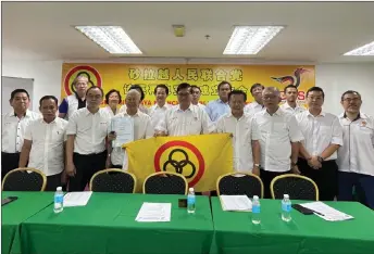  ?? ?? Chen (front, centre) receiving the party’s constituti­on and banner from Ting (front, fourth left), as others look on.