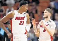  ?? WILFREDO LEE/AP ?? Miami Heat center Hassan Whiteside (21) and guard Tyler Johnson discuss strategy last week against Atlanta.