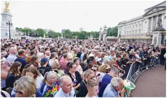  ?? ?? Look out: At Buckingham Palace, crowds wait to catch a glimpse of the King