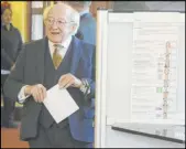 ?? Brian Lawless The Associated Press ?? Irish President Michael Higgins casts his vote in the parliament­ary elections at a polling station Saturday in Dublin.