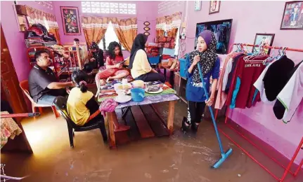  ??  ?? In deep water: A family of seven making the best of their situation in their flooded home at Kampung Tok Subuh, Bukit Mertajam. — MUSTAFA AHMAD/The Star