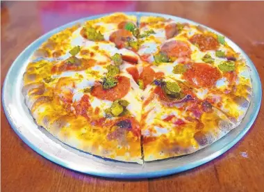  ?? RICHARD S. DARGAN/FOR THE JOURNAL ?? Boxing Bear offers six versions of its 10-inch pizzas, including the pepperoni with green chile, mozzarella and red sauce.