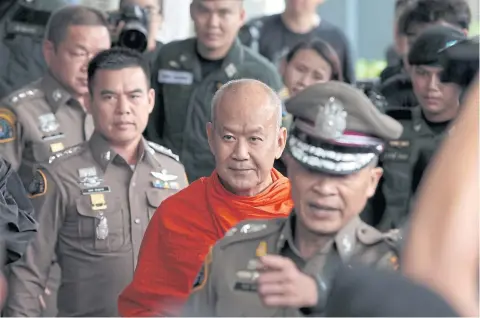  ??  ?? Former Phra Phrom Sitthi, or Thongchai Sukkho, is escorted to the Central Criminal Court for Corruption and Misconduct Cases in Bangkok’s Dusit district after surrenderi­ng to police. He was defrocked later yesterday and detained after the court...