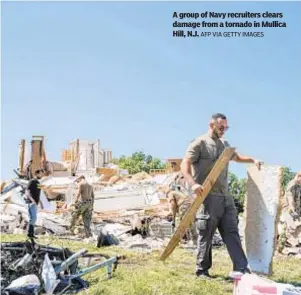  ?? AFP VIA GETTY IMAGES ?? A group of Navy recruiters clears damage from a tornado in Mullica Hill, N.J.