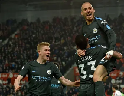  ?? AFP ?? Manchester City’s David Silva leaps into the arms of Gabriel Jesus after scoring his second goal against Stoke City. —