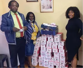  ?? ?? Pictured is the headmaster and teacher from Sibongumbo­mvu Combined High School receiving the school shoes donation from Reinvent Women SA founder Nolwazi Moepeng.