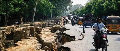  ?? ?? PENDUDUK melalui laluan yang merekah akibat kesan gempa bumi di sepanjang Jalan Myo Patt yang menghubung­kan Mandalay dan Sagaing.