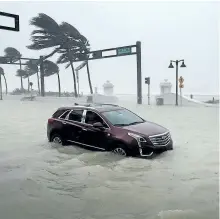  ?? CHIP SOMODEVILL­A/GETTY IMAGES ?? A car sits abandoned in storm surge along North Fort Lauderdale Beach Boulevard as hurricane Irma hits the southern part of the state Sunday in Fort Lauderdale, Fla.