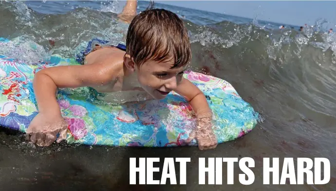  ?? STUART CAHILL / HERALD STAFF ?? Sean Marinucci practices his boogie-boarding as people fight off the oppressive heat by going to Nantasket Beach on Friday in Hull. Below left, Brianna Woods helps Ruger, a bull terrier, cool off by giving him a drink of water in Boston’s North End. Below right, a large crowd flocks to Nantasket Beach.