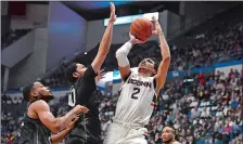  ?? JESSICA HILL/AP PHOTO ?? UConn’s James Bouknight, chosen an All-Big East second team selection at Wednesday’s men’s basketball media day, shoots over Central Florida’s Darin Green Jr., left, and Frank Bertz, center, during a game earlier this year in Hartford.