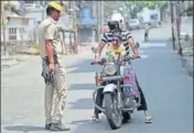  ?? AP ?? A policeman stops a motorist during reimposed weekend lockdown in Jammu on Sunday.