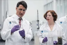  ?? JASON FRANSON THE CANADIAN PRESS ?? Prime Minister Justin Trudeau and Dr. Heather Kaminsky test clay, water and bitumen from a tailings pond for recycling during a visit to the Northern Alberta Institute of Technology's Productivi­ty and Innovation Centre, in Edmonton on Wednesday.