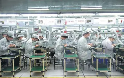  ?? PROVIDED TO CHINA DAILY ?? Employees of Foxconn Technology Group work at a production line of the company in Zhengzhou, capital of Henan province.